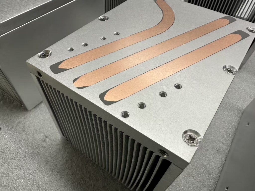 Heat Pipe Heat Sink Close-up — Embedded Copper Pipes and Screw Assembly Close-up of a heat pipe heat sink with embedded copper heat pipes, Torx screws and tapped mounting holes